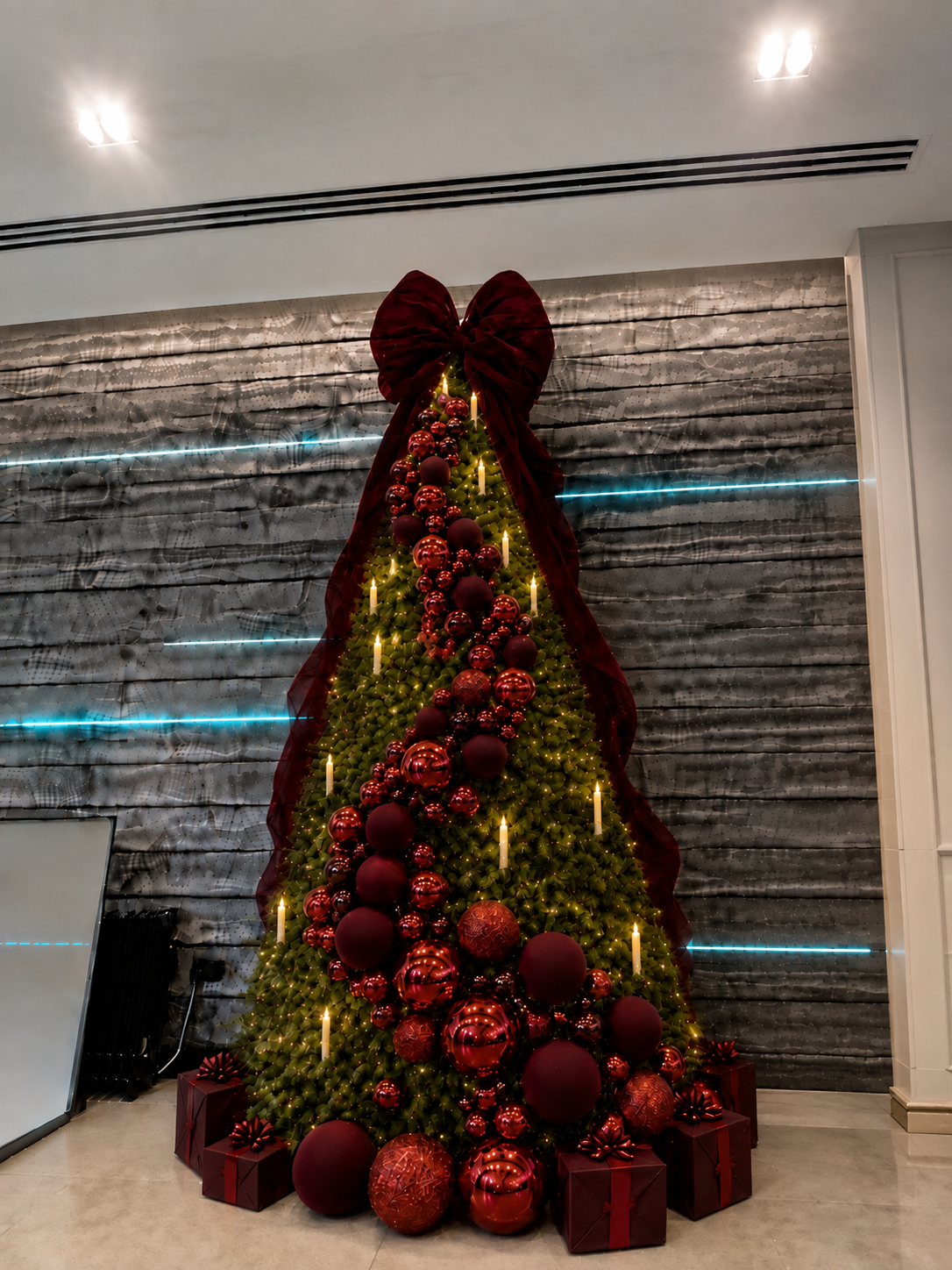 Statement Christmas tree with oversized burgundy ribbon and red baubles